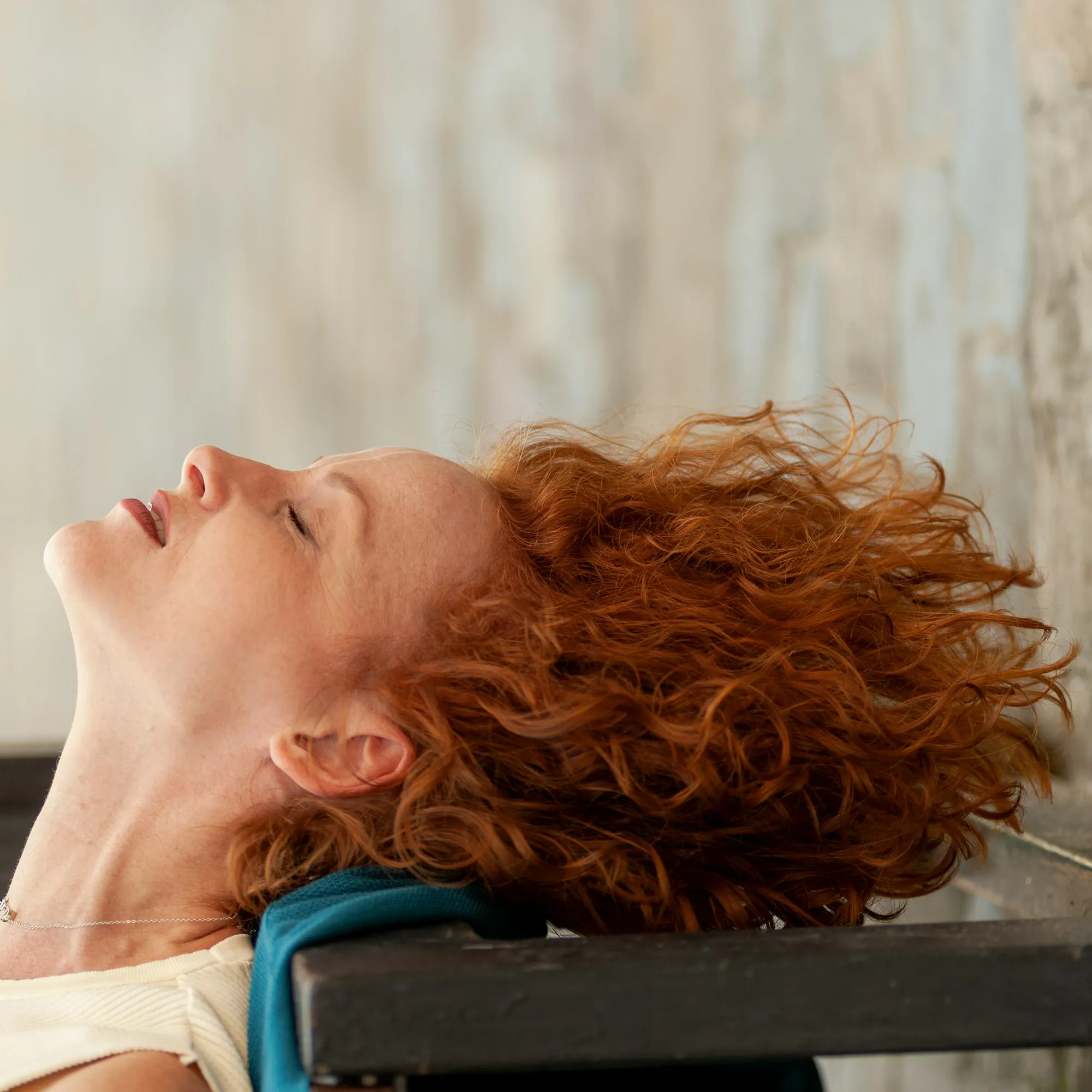 Woman lying on a reformer with her head on the headrest