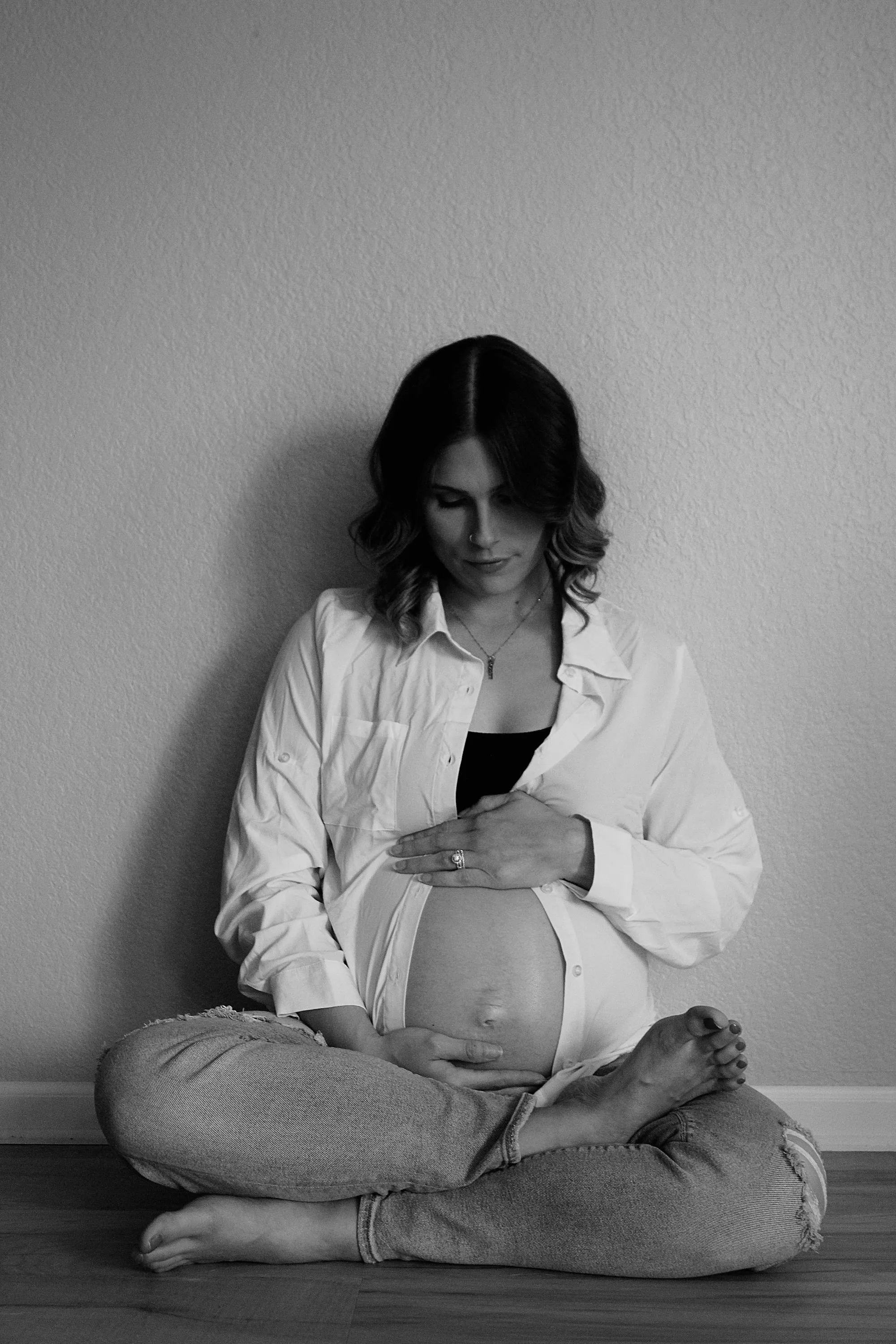 Pregnant woman sitting calmly cross-legged, hands on her belly